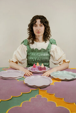 Woman sitting at the colorful festive table serving with jelly dessert