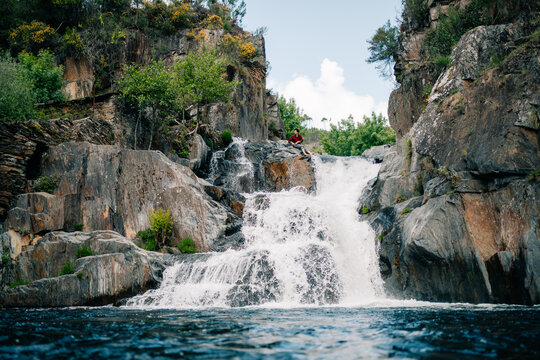 Cascading Water Flows Down Rocks Near a Person in a Natural Setting