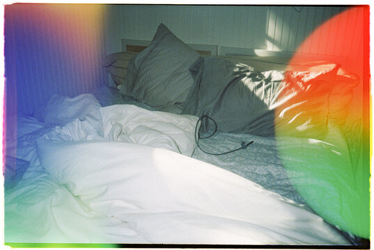 Bed With Messy Sheets and Pillows in a Light Space