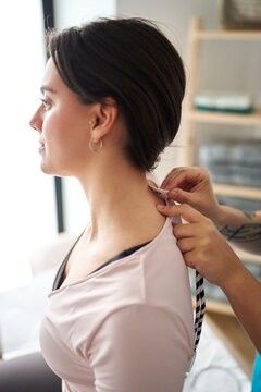 Woman receiving neurostimulation TENS therapy for neck pain