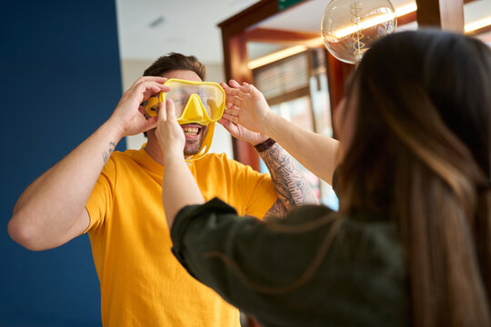 Person trying on yellow diving mask in dive center