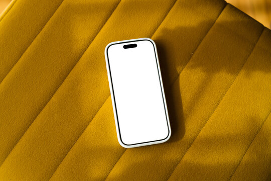 Mobile phone on couch with empty screen ready for use    