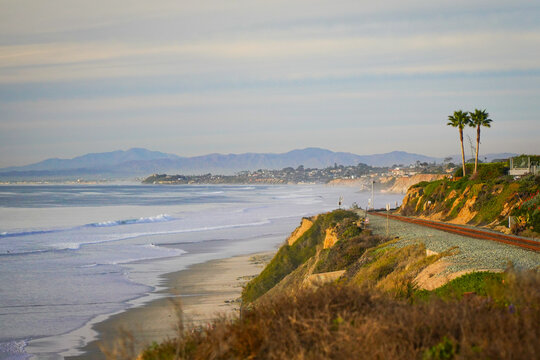 Coastal railroad along the Del Mar bluffs with palms and distant mountains