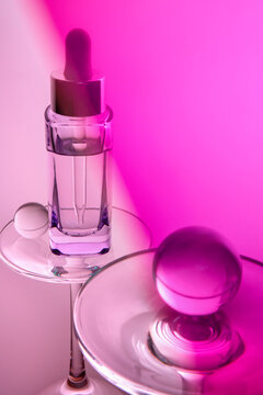 Purple serum in a glass dropper bottle on violet pink background