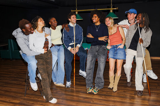 Cheerful friends enjoying billiards game together