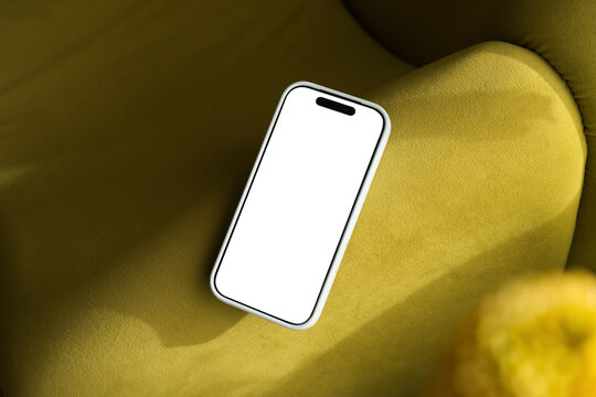 Mobile phone on couch with empty screen ready for use    