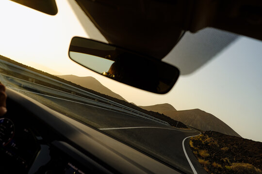 Driving on a winding road in the mountains at sunset