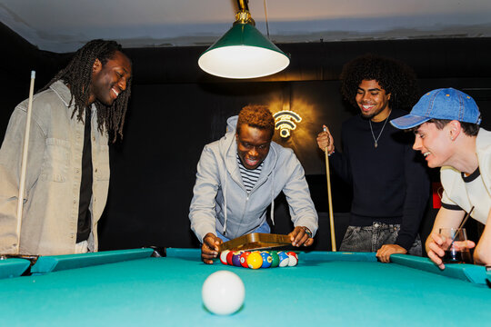 Friends playing billiards together in a pub