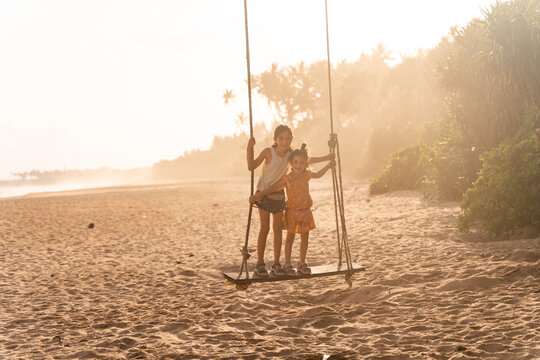 Children Playing on Beach Swing at Sunset. Sri Lanka
