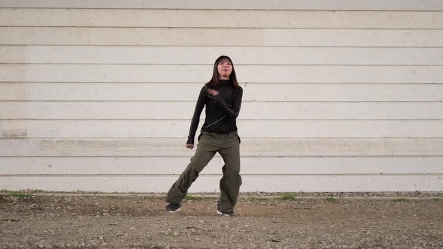 白い壁を背にダンスの練習をする女性ダンサー