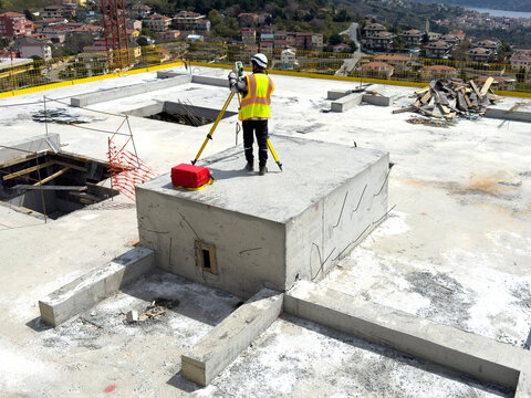 Land Surveyor Measuring at Construction Site with Total Station