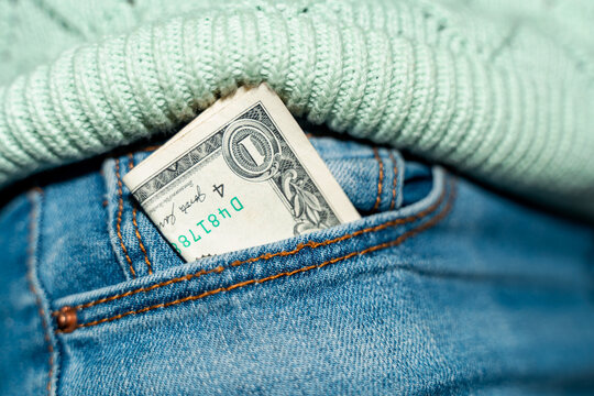 One Dollar Bill Tucked in Denim Pocket During Daytime