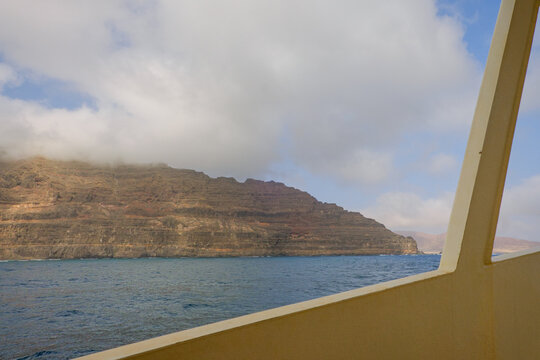Boat view of the coast and mountains near the sea with clouds