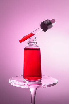 Red serum in a glass dropper bottle. Dramatic wide-angle perspective