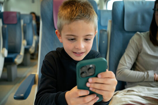 Child Using Smartphone On Public Train
