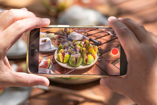Influencer filming food content with phone for social media