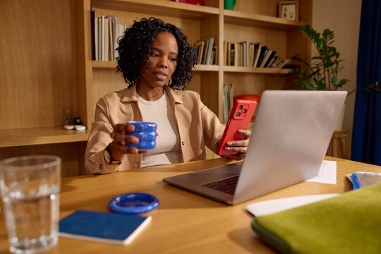 Woman pauses for coffee and looks at her phone.