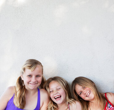 Three Girls Up Against Wall Laughing