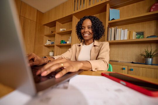 Attractive woman working from home, typing on a laptop