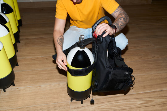 Diver preparing scuba diving gear at dive center