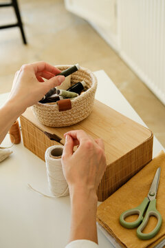 A closeup of a person selecting colorful threads from a small box.