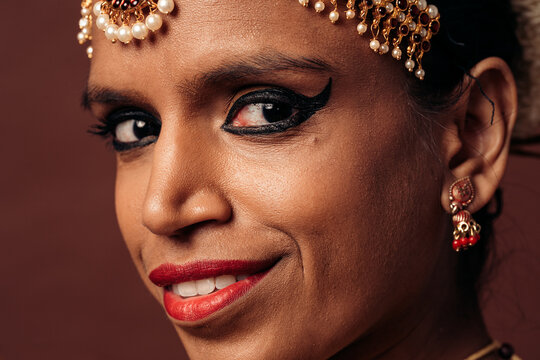 Young indian woman smiling wearing traditional jewelry and makeup