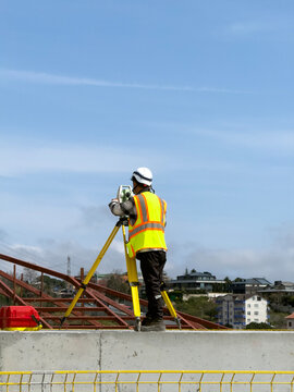 Land Surveyor Measuring at Construction Site with Total Station