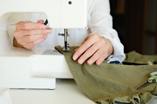 A closeup of a person using a sewing machine.