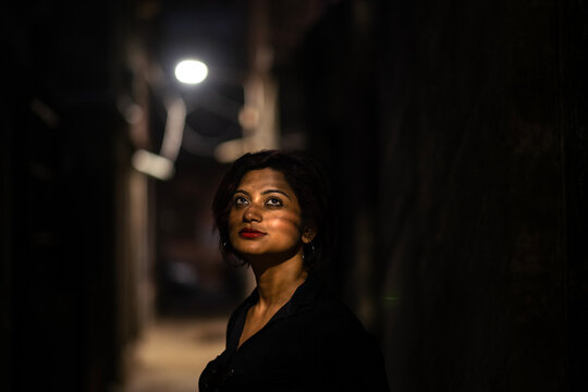 Portrait of and Indian woman at night in the alleyway of a city