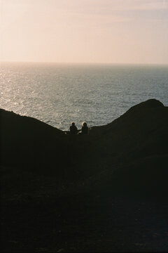 Silhouettes of two anonymous friends watching the sunset