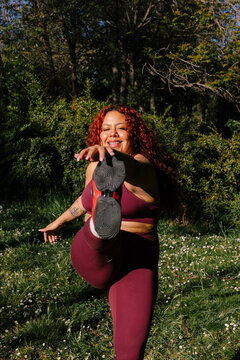 A plus-size athlete performs isometric exercises in a park
