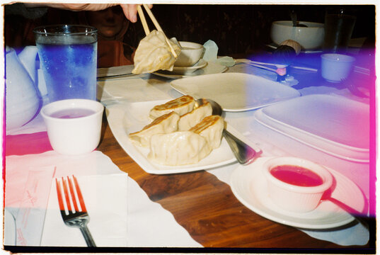 Eating Dumplings With Chopsticks at a Restaurant Table in Evening