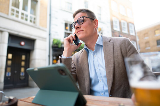 Man talking on phone at outdoor cafe