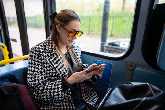 Commuter using smartphone on London bus
