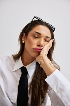 Woman resting her head on her hand in a simple setting