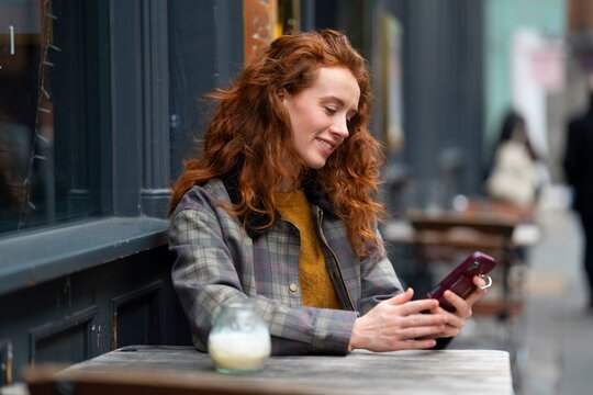 Using smartphone at outdoor cafe