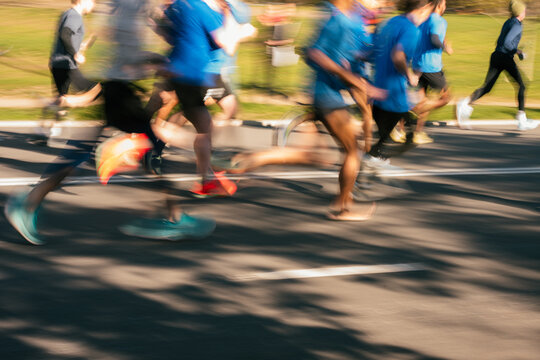 Motion blur of runners racing on city street