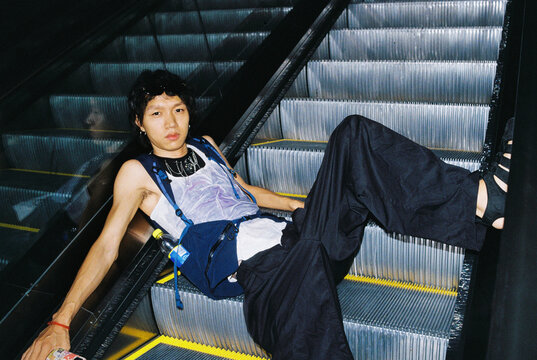 Edgy portrait lounging on escalator in urban interior