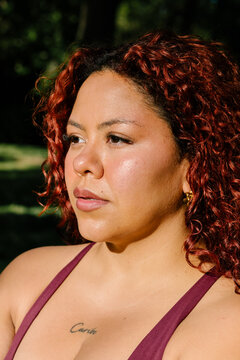 A close daylight frame shows a curvy woman modeling in a park