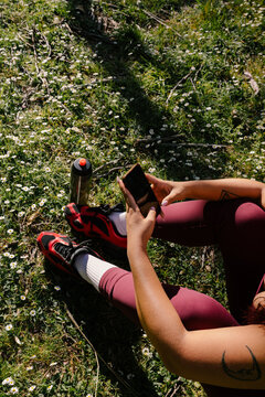 Unknown curvy woman in sportswear checking her smartphone