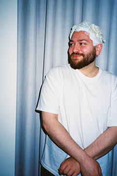 Man with bleach on hair smiling indoors