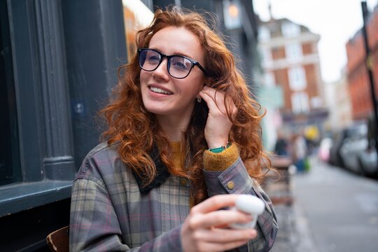 Putting on wireless earbuds at cafe