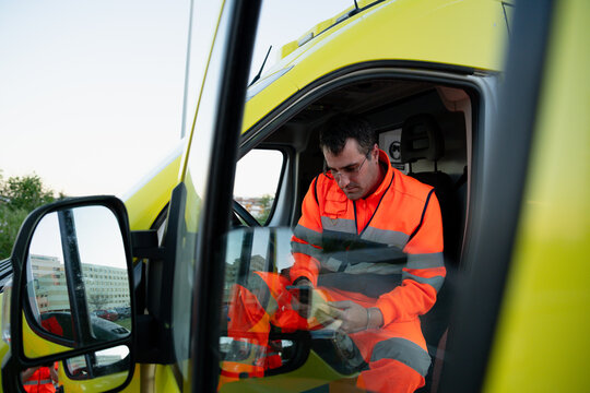 Paramedic checking equipment inside ambulance