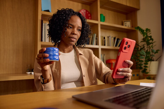 Woman enjoys a coffee break while checking her phone.