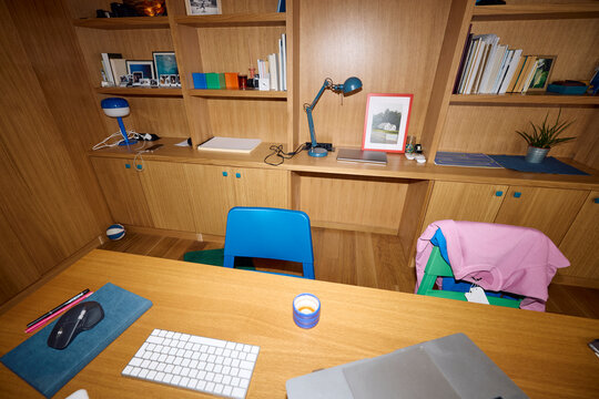 Desk Setup in a Wooden Room With a Chair and Lamp