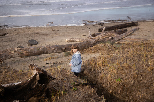 A Girl Standing on Beach Looking Back At Camera