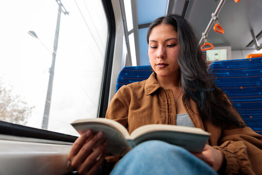 Woman reading book on train