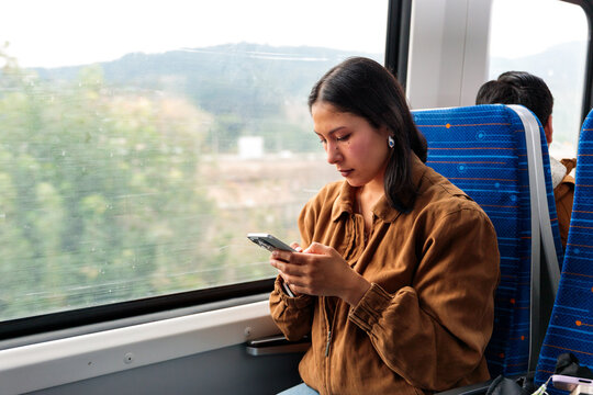 Woman using phone on train