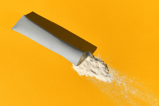 Sachet with collagen and vitamins in powder form on yellow background.