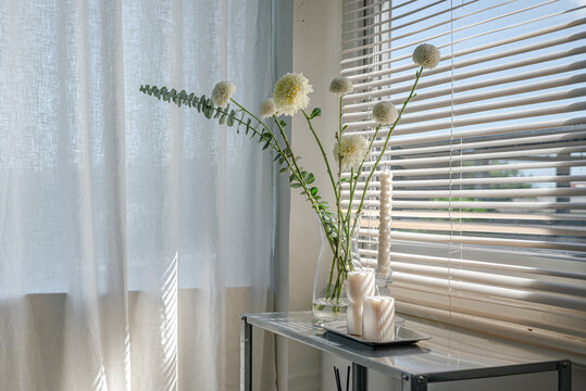 Flowers and Candles by Window in Soft Natural Light